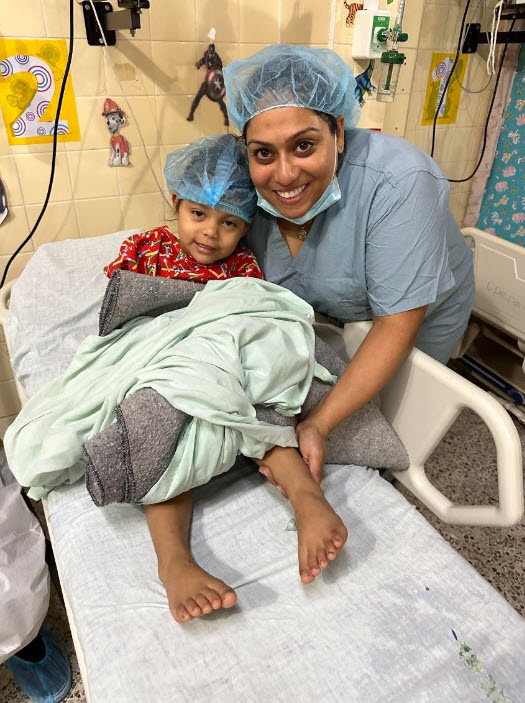 Dr Hasmukh smiles alongside a young patient